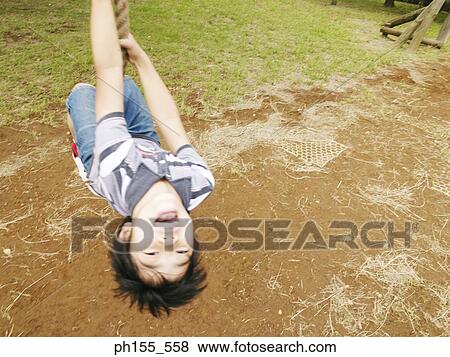 High angle view of a boy swinging on a rope View Large Photo Image Stock Photo - High angle view of a boy swinging on a rope. Fotosearch
