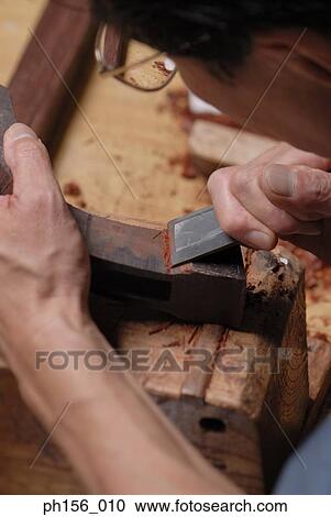 High angle view of a carpenter peeling wood with a chisel View Large Photo Image Stock Image - High angle view of a carpenter peeling wood with a chisel. Fotosearch