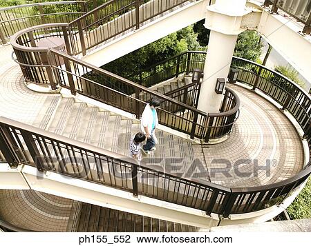 Stock Image - High angle view of a father and his son walking downstairs. Fotosearch