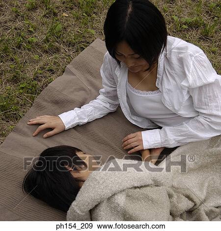 High angle view of a girl sleeping beside her mother View Large Photo Image Stock Photo - High angle view of a girl sleeping beside her mother. Fotosearch