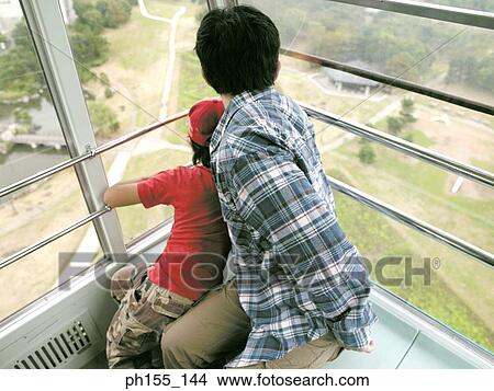 High angle view of a man and his son sitting in a trolley View Large Photo Image Picture - High angle view of a man and his son sitting in a trolley. Fotosearch