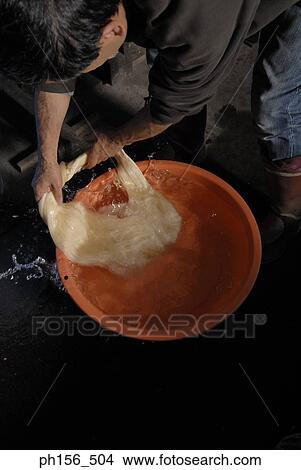 High angle view of a man washing silk threads in water View Large Photo Image Picture - High angle view of a man washing silk threads in water. Fotosearch