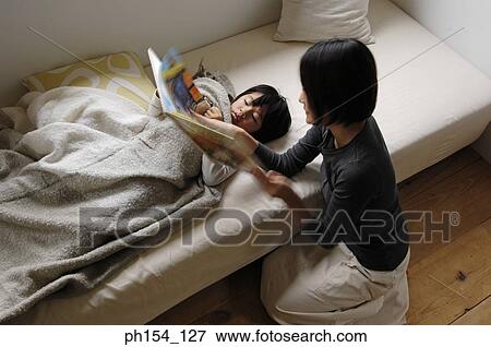 Stock Photo - High angle view of a mid adult woman teaching her son. Fotosearch