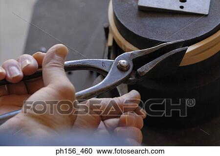 High angle view of a person's hand bending a wooden strip with the help of a pair of pliers View Large Photo Image Stock Image - High angle view of a person's hand bending a wooden strip with the help of a pair of pliers. Fotosearch