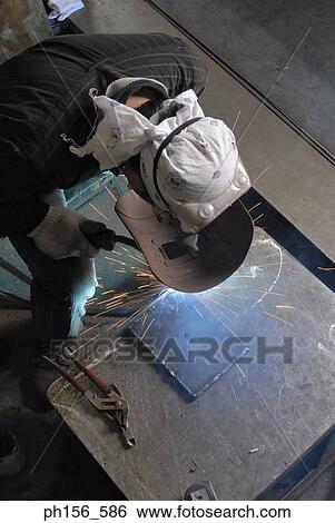 High angle view of a welder welding in a workshop View Large Photo Image Stock Photograph - High angle view of a welder welding in a workshop. Fotosearch