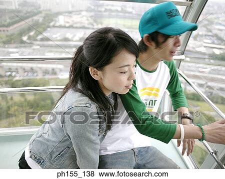 Stock Photo - High angle view of a young couple looking outside a trolley. Fotosearch