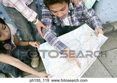 High angle view of a young man and a young woman looking at a map View Large Photo Image Stock Photo - High angle view of a young man and a young woman looking at a map. Fotosearch