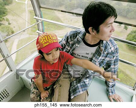 High angle view of a young man and his son looking out of a trolley View Large Photo Image Stock Photography - High angle view of a young man and his son looking out of a trolley. Fotosearch