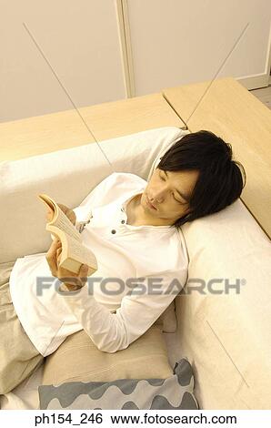 High angle view of a young man reading a book View Large Photo Image Stock Photograph - High angle view of a young man reading a book. Fotosearch