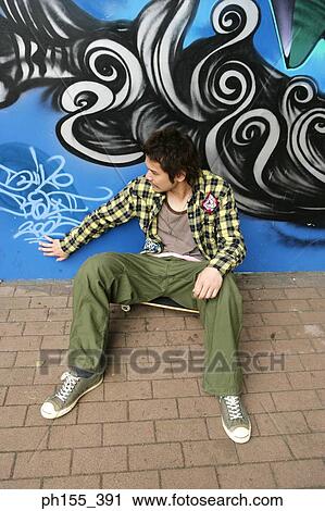 High angle view of a young man sitting in front of a graffiti View Large Photo Image Stock Image - High angle view of a young man sitting in front of a graffiti. Fotosearch