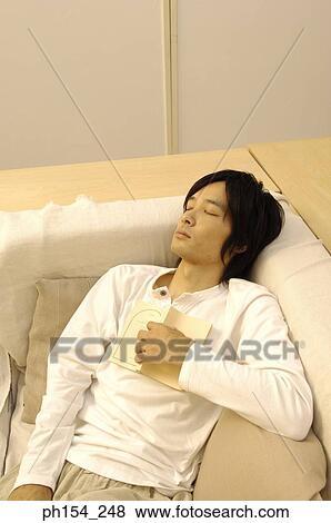 High angle view of a young man sleeping with a book View Large Photo Image Stock Photo - High angle view of a young man sleeping with a book. Fotosearch
