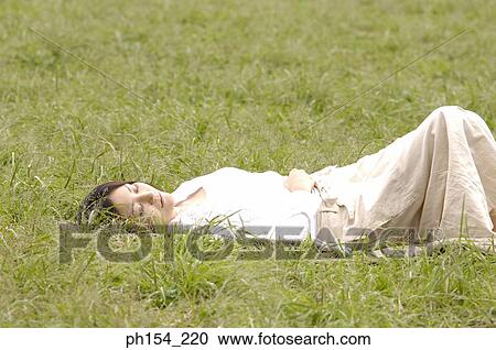 High angle view of a young woman sleeping on the grass View Large Photo Image Stock Image - High angle view of a young woman sleeping on the grass. Fotosearch