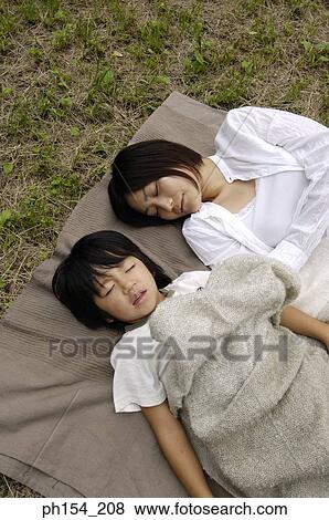 High angle view of a young woman sleeping with her daughter View Large Photo Image Stock Photo - High angle view of a young woman sleeping with her daughter. Fotosearch