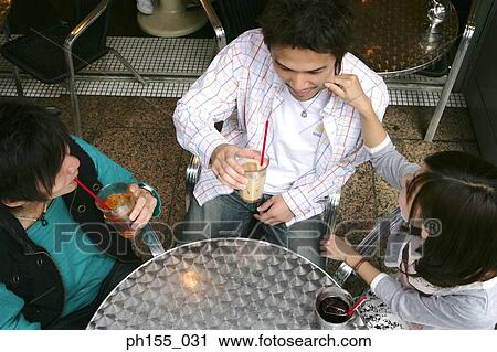 High angle view of three friends sitting together in a restaurant View Large Photo Image Stock Image - High angle view of three friends sitting together in a restaurant. Fotosearch