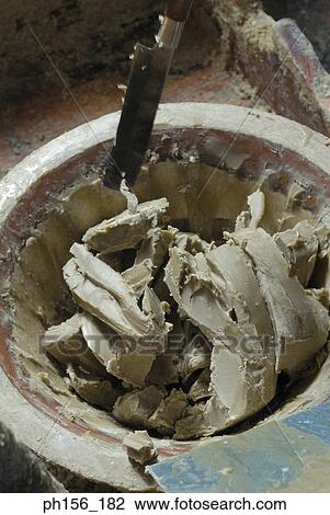 Stock Image - High angle view of wax and a knife in a terracotta pot. Fotosearch