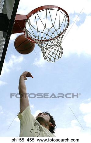 Low angle view of a basketball player shooting a basket ball into a hoop View Large Photo Image Stock Photography - Low angle view of a basketball player shooting a basket ball into a hoop. Fotosearch