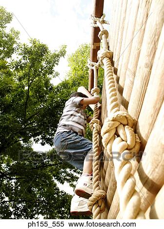 Low angle view of a boy climbing a jungle gym View Large Photo Image Stock Photography - Low angle view of a boy climbing a jungle gym. Fotosearch