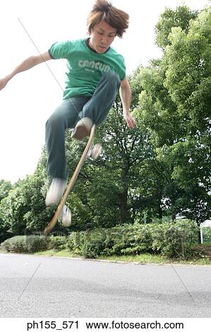 Low angle view of a boy skateboarding View Large Photo Image Stock Image - Low angle view of a boy skateboarding. Fotosearch