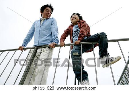 Low angle view of a mid adult man and his son View Large Photo Image Stock Image - Low angle view of a mid adult man and his son. Fotosearch