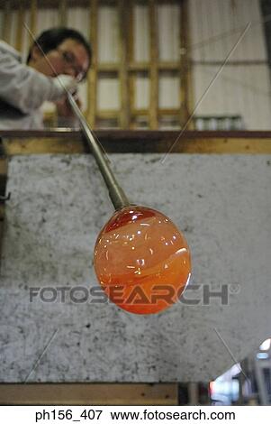 Stock Photo - Low angle view of a mid adult man molding a glass bulb. Fotosearch
