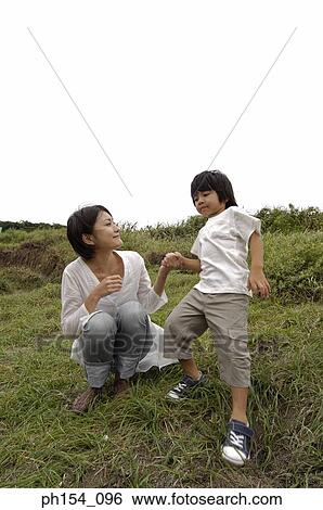 Low angle view of a mid adult woman crouching near her son View Large Photo Image Stock Photograph - Low angle view of a mid adult woman crouching near her son. Fotosearch