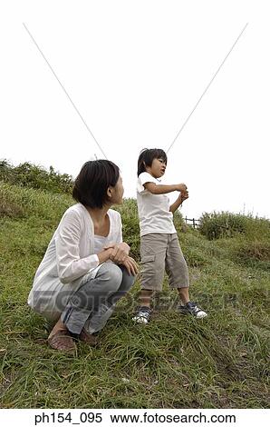 Low angle view of a mid adult woman crouching near her son View Large Photo Image Stock Photography - Low angle view of a mid adult woman crouching near her son. Fotosearch