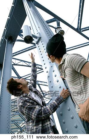Low angle view of a young couple looking up View Large Photo Image Stock Image - Low angle view of a young couple looking up. Fotosearch