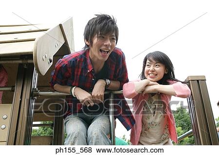 Low angle view of a young couple bending forward over a railing View Large Photo Image Stock Photo - Low angle view of a young couple bending forward over a railing. Fotosearch