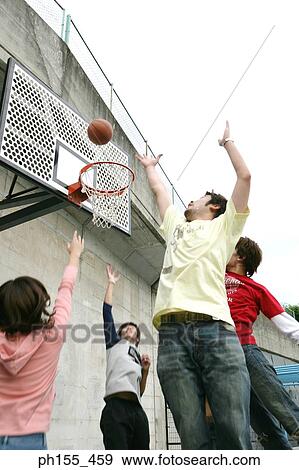 Low angle view of five people shooting a basket ball into a hoop View Large Photo Image Stock Photo - Low angle view of five people shooting a basket ball into a hoop. Fotosearch