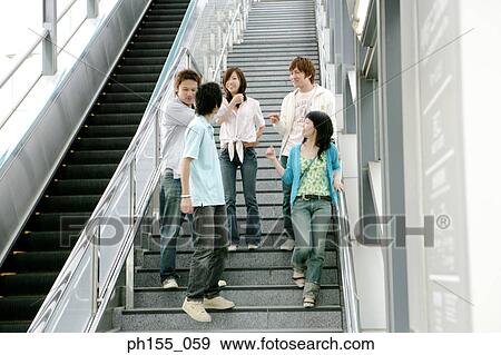 Low angle view of five people talking together on a staircase View Large Photo Image Stock Photo - Low angle view of five people talking together on a staircase. Fotosearch