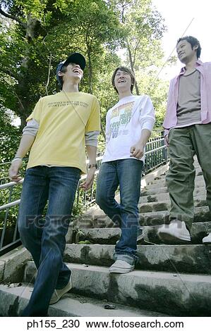 Low angle view of three young men walking down steps View Large Photo Image Stock Image - Low angle view of three young men walking down steps. Fotosearch