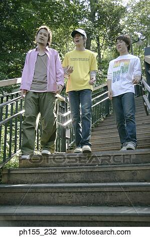Low angle view of three young men walking down steps View Large Photo Image Stock Image - Low angle view of three young men walking down steps. Fotosearch