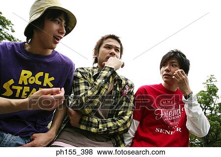 Low angle view of three young men View Large Photo Image Stock Photo - Low angle view of three young men. Fotosearch