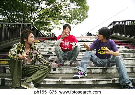 Low angle view of three young men sitting on steps View Large Photo Image Stock Photography - Low angle view of three young men sitting on steps. Fotosearch