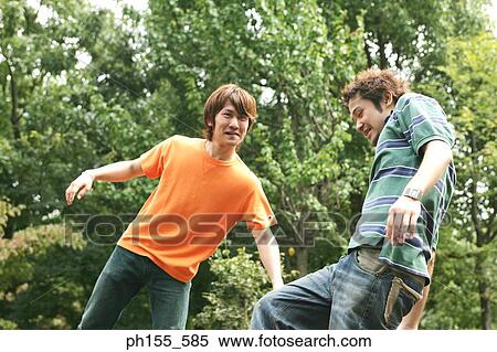 Low angle view of two young men smiling View Large Photo Image Stock Photography - Low angle view of two young men smiling. Fotosearch