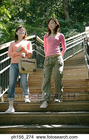 Low angle view of two young women moving down on steps View Large Photo Image Picture - Low angle view of two young women moving down on steps. Fotosearch