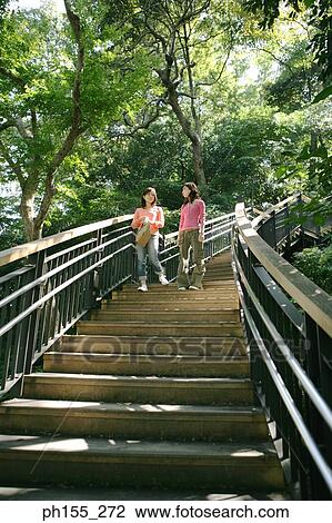 Low angle view of two young women moving down on steps View Large Photo Image Stock Image - Low angle view of two young women moving down on steps. Fotosearch