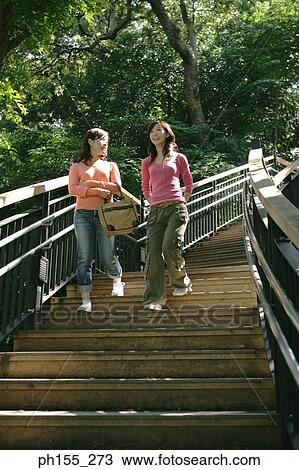 Low angle view of two young women moving down on steps View Large Photo Image Stock Image - Low angle view of two young women moving down on steps. Fotosearch