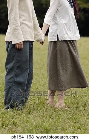 Low section view of a man holding a woman's hand View Large Photo Image Stock Photo - Low section view of a man holding a woman's hand. Fotosearch