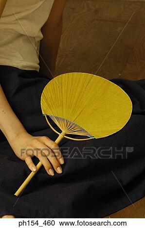 Low section view of a woman holding a fan View Large Photo Image Stock Image - Low section view of a woman holding a fan. Fotosearch