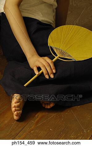 Low section view of a woman holding a fan View Large Photo Image Stock Photo - Low section view of a woman holding a fan. Fotosearch
