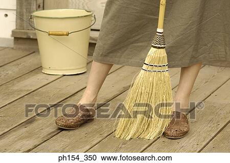 Low section view of a woman with a broom View Large Photo Image Stock Image - Low section view of a woman with a broom. Fotosearch