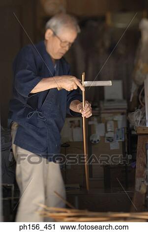Mature man dividing a wooden stick View Large Photo Image Stock Image - Mature man dividing a wooden stick. Fotosearch