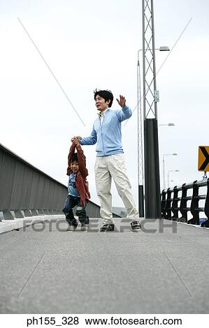 Mid adult man and his son on a bridge View Large Photo Image Stock Photo - Mid adult man and his son on a bridge. Fotosearch