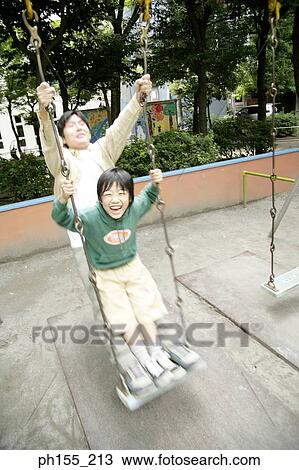 Mid adult man and his son sitting on a swing View Large Photo Image Stock Image - Mid adult man and his son sitting on a swing. Fotosearch