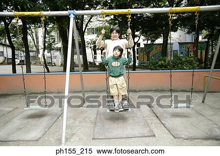 Mid adult man and his son sitting on a swing View Large Photo Image Stock Photography - Mid adult man and his son sitting on a swing. Fotosearch