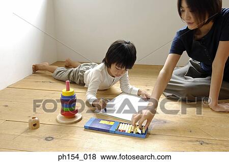 Mid adult woman and her daughter coloring in a coloring book View Large Photo Image Stock Photo - Mid adult woman and her daughter coloring in a coloring book. Fotosearch