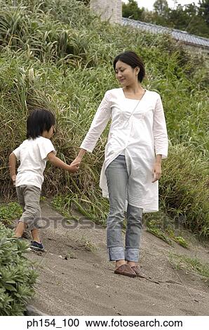Mid adult woman standing with her son View Large Photo Image Stock Image - Mid adult woman standing with her son. Fotosearch