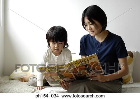 Picture - Mid adult woman teaching her daughter. Fotosearch