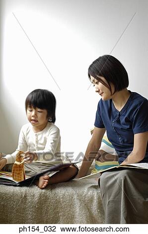 Mid adult woman teaching her daughter View Large Photo Image Stock Image - Mid adult woman teaching her daughter. Fotosearch